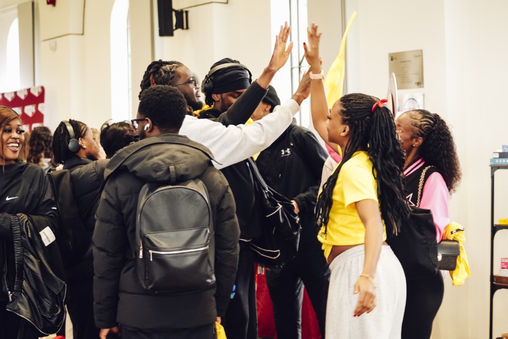 Group of students high fiving at an event